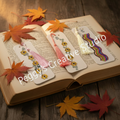 Three handmade diamond art bookmarks with tassels displayed on an open book with autumn maple leaves